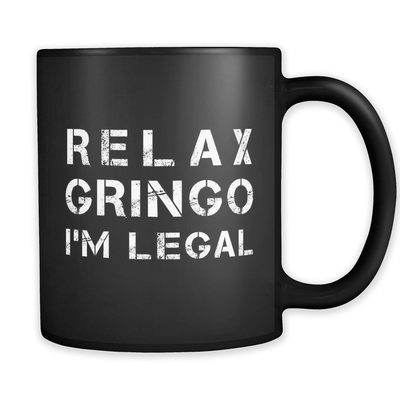 May include: Black coffee mug with white text that reads "Relax Gringo I'm Legal".