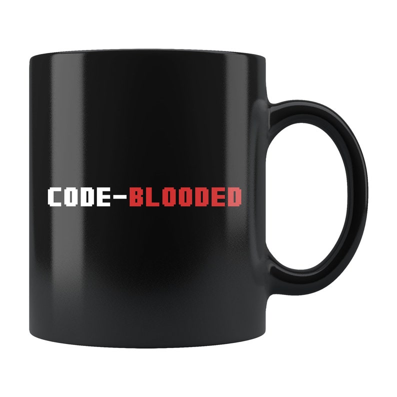 Op de afbeelding: Zwarte keramische koffiemok met witte tekst die "CODE-BLOODED" luidt in een gepixelde lettertype. Het woord "BLOODED" is rood.