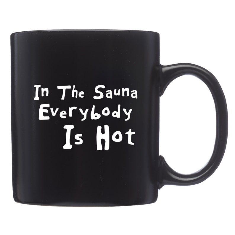 Peut inclure: Mug en c&eacute;ramique noire avec une anse incurv&eacute;e. Le mug pr&eacute;sente un texte blanc qui dit "In The Sauna Everybody Is Hot". Le mug est con&ccedil;u pour les boissons chaudes.