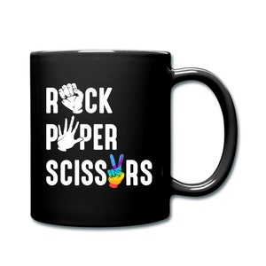 May include: Black coffee mug with white text that reads "Rock Paper Scissors" with a rainbow colored peace sign for the "Scissors" part.