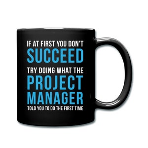 May include: Black coffee mug with white text that reads "If at first you don't succeed, try doing what the project manager told you to do the first time". The text "project manager" is in blue.