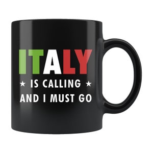 以下が含まれることがあります： 黒色のセラミック製のマグカップで、白文字で「ITALY IS CALLING AND I MUST GO」と書いてあります。「ITALY」という単語は、イタリアの国旗を思わせる緑、白、赤で書かれています。