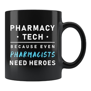May include: Black ceramic mug with the text "PHARMACY TECH" above the text "BECAUSE EVEN PHARMACISTS NEED HEROES". The text is in white and light blue. The mug has a curved handle.