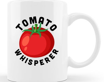 Może przedstawiać: Biały ceramiczny kubek do kawy z czarnym nadrukiem pomidora i tekstem "Tomato Whisperer".