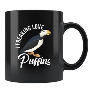 May include: Black ceramic coffee mug with a white graphic of a puffin and the text "I Freaking Love Puffins".