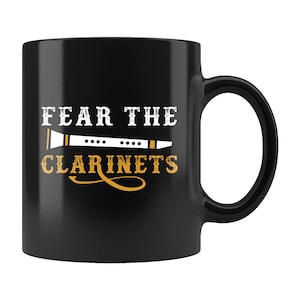 May include: Black coffee mug with a white design that says "Fear the Clarinets" with a white clarinet graphic.