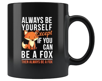 May include: Black coffee mug with a white fox illustration and the text "ALWAYS BE YOURSELF Except IF YOU CAN BE A FOX THEN ALWAYS BE A FOX".