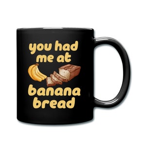 May include: Black coffee mug with a yellow graphic that says "you had me at banana bread" with a cartoon banana and loaf of banana bread.
