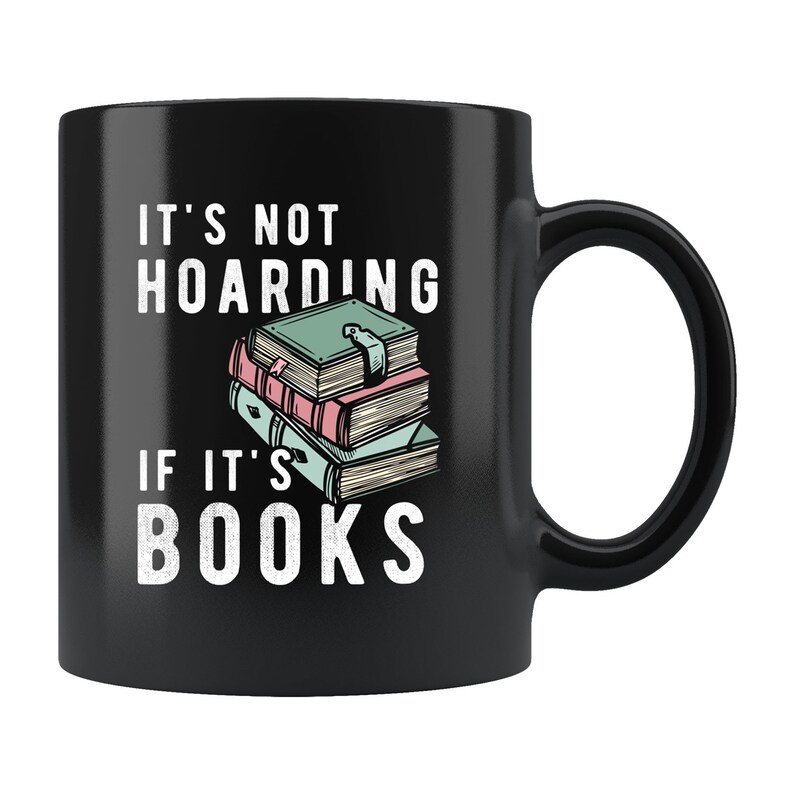 May include: Black coffee mug with white text that reads "It's not hoarding if it's books". A stack of colorful books is pictured on the mug.