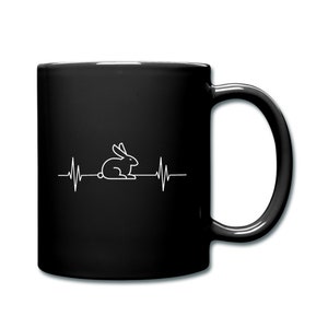May include: Black coffee mug with a white outline of a rabbit inside a heartbeat graphic.