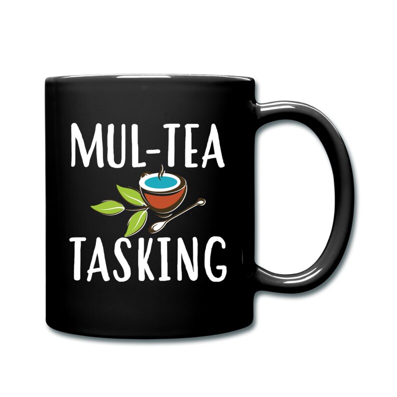 May include: Black coffee mug with white text that reads "Mul-tea Tasking" and a cartoon image of a teacup with a spoon.
