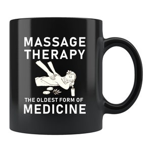 May include: Black coffee mug with white text that reads "Massage Therapy The Oldest Form of Medicine". The mug features a line drawing of a person receiving a massage.