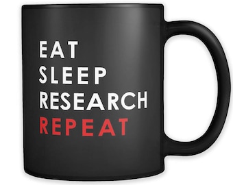 May include: Black coffee mug with white text that reads "Eat Sleep Research Repeat". The word "Repeat" is in red.