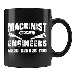 May include: Black ceramic mug with the text "MACHINIST BECAUSE ENGINEERS NEED HEROES TOO" in white. The mug features illustrations of wrenches. A perfect gift for machinists and engineers.