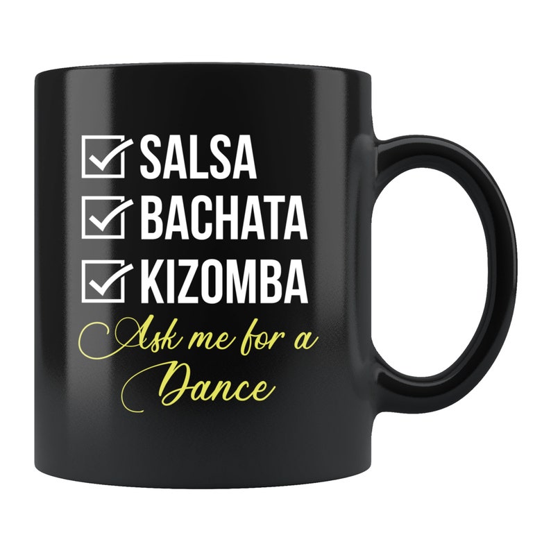Puede incluir: Taza de cer&aacute;mica negra con un dise&ntilde;o de lista de verificaci&oacute;n de Salsa, Bachata y Kizomba en blanco. La taza tambi&eacute;n presenta el texto "Ask me for a Dance" en una fuente cursiva. La taza tiene un asa curva.