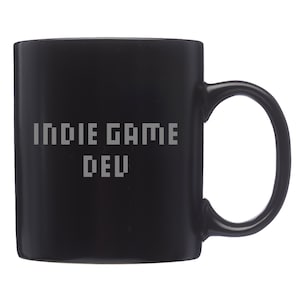 May include: Black ceramic coffee mug with the text "Indie Game Dev" in a pixelated font.