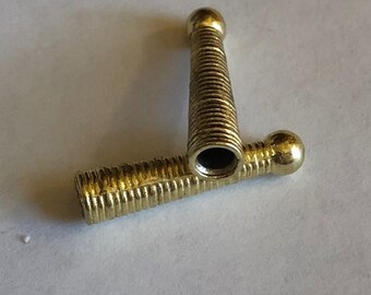 May include: Two gold-colored metal caps with a threaded design. The caps have a rounded top and a threaded bottom.