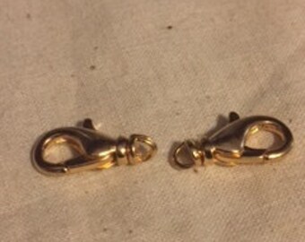 May include: Two gold-toned metal lobster clasps, each with a spring-loaded gate.