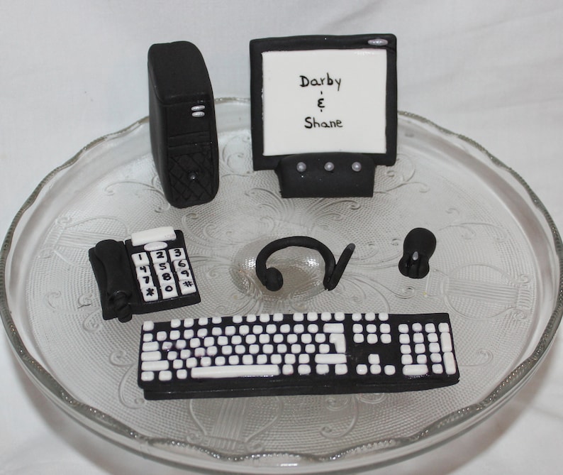 May include: Black and white computer themed cake decorations. The set includes a computer monitor with the text "Darby & Shane", a desktop computer, a keyboard, a phone, a headset, and a mouse.