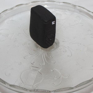 May include: A black computer tower on a clear glass plate with a decorative pattern.