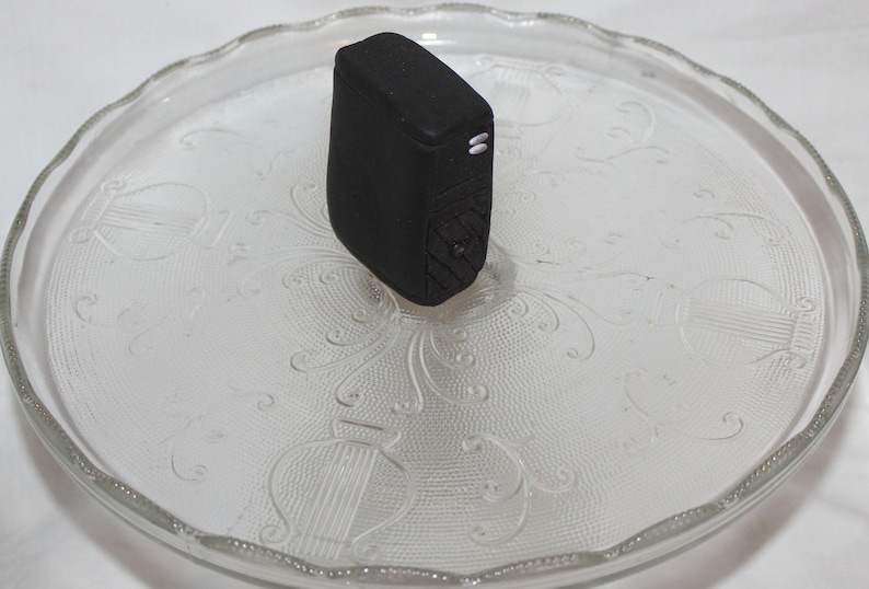 May include: A black computer tower on a clear glass plate with a decorative pattern.