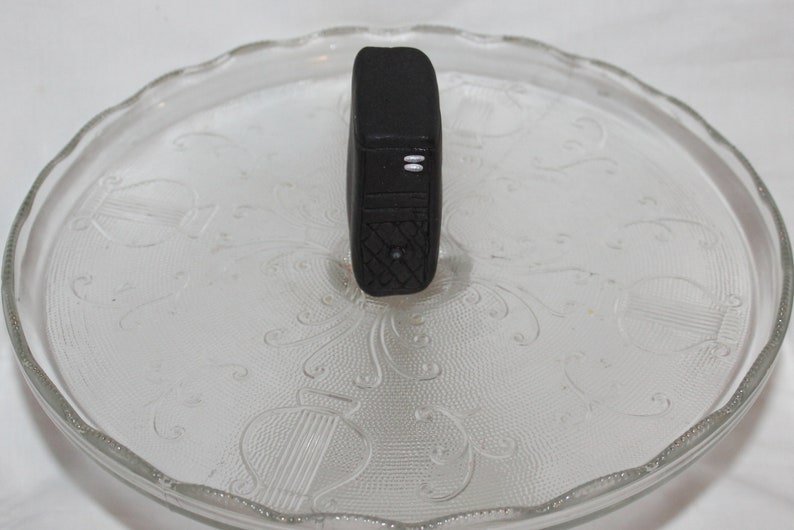 May include: A black fitness tracker with a textured surface and two white lines on the front.