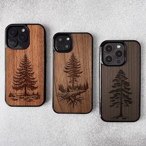 May include: Three wooden phone cases with black borders. Each case features a detailed laser-etched design of a pine tree. The wood tones vary from light to dark brown, showcasing the natural grain. The cases are for a smartphone.