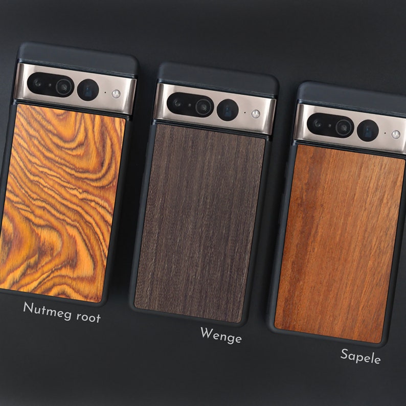May include: Three phone cases with wooden backings are displayed. The cases have a black frame and a silver camera bar. The wooden backings are labeled "Nutmeg root", "Wenge", and "Sapele", each with a unique wood grain pattern and color.