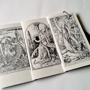 May include: A booklet featuring three black and white ink illustrations. The left panel shows a figure embracing a dragon with the text "THE KISS THAT GAVE THE VICTORY". The right panel depicts a figure in a forest with the text "The Magician's Wife Christens the New Planet".