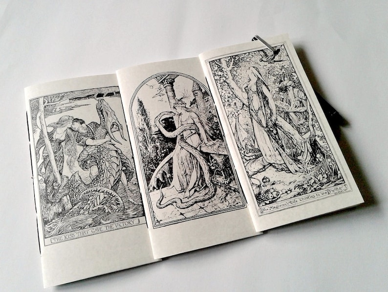 May include: A booklet featuring three black and white ink illustrations. The left panel shows a figure embracing a dragon with the text "THE KISS THAT GAVE THE VICTORY". The right panel depicts a figure in a forest with the text "The Magician's Wife Christens the New Planet".
