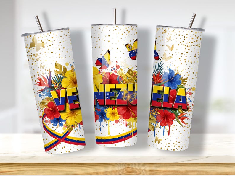 May include: Three white insulated tumblers with the word "VENEZUELA" in red, yellow, and blue, the colors of the Venezuelan flag. The tumblers feature floral and butterfly designs, with gold accents and a straw.
