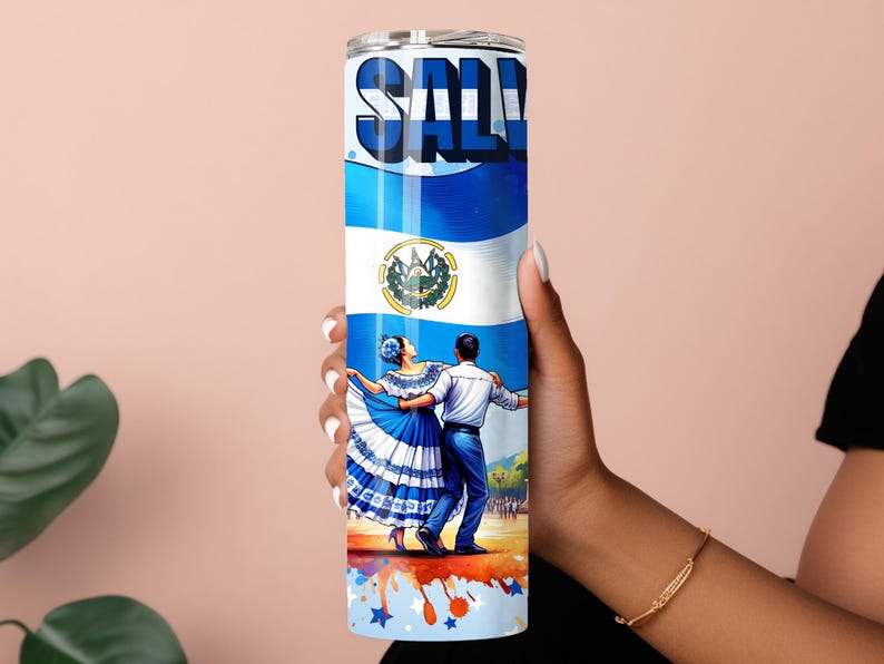 May include: A stainless steel tumbler with a colorful design featuring the flag of El Salvador, a couple dancing in traditional dress, and the word "SALVADOR" in large letters. The tumbler has a blue, white, and red color scheme.