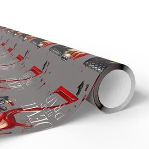May include: Rolled gray wrapping paper featuring a repeating pattern of fashion-related illustrations. The design includes red high heels, black handbags, and the text "The Devil Wears Prada" in white.