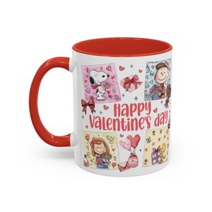 May include: A white ceramic mug with a red interior and handle. The mug features a Valentine's Day design with Snoopy, Charlie Brown, and other Peanuts characters. The words "Happy Valentine's Day" are also printed on the mug.