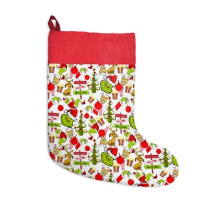 May include: A Christmas stocking with a red cuff and a white body featuring a repeating pattern of the Grinch, Max the dog, Cindy Lou Who, Christmas trees, presents, and signs reading Mount Crumpit, Who-Ville, and Grinch's Lair.