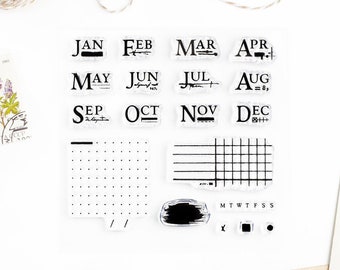 May include: A set of 12 clear rubber stamps featuring the months of the year in a vintage font. The stamps also include a grid, a dotted grid, a brush stroke, and the days of the week.