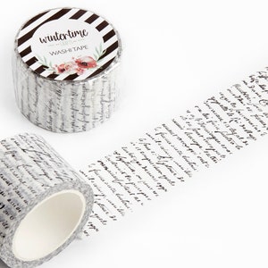 May include: A roll of white washi tape with black cursive writing and a label that says "wintertime washi tape" with a black and white striped background and a floral design.