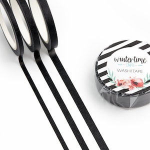 May include: Three rolls of black washi tape with a roll of black and white striped washi tape with a floral design and the text "wintertime crafts washi tape".