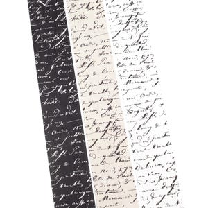May include: Three rolls of decorative washi tape with handwritten script in black, off-white, and gray. The tape is angled, showing the script in a repeating pattern. The tape is ideal for scrapbooking and crafts.