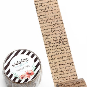 May include: A roll of brown washi tape with black and white stripes and a floral design. The tape has a handwritten text pattern. The text reads "wintertime crafts washi tape".