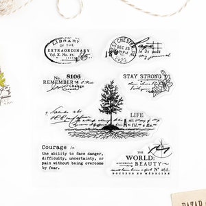 May include: A set of nine clear rubber stamps with black ink. The stamps feature various designs, including a tree, a library stamp, a vintage postmark, a quote about courage, and a quote about the world's beauty. The stamps are perfect for adding a vintage touch to your crafting projects.