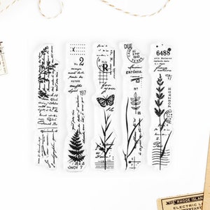 May include: Set of four clear rubber stamps with black ink designs. The stamps feature botanical illustrations, including ferns, grasses, and butterflies. The stamps also include text, such as "DUE", "gardens", "POSTAGE", and "6488".