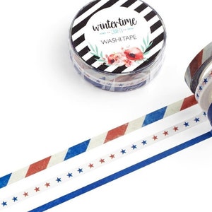 May include: A roll of blue, red, and white patterned washi tape with stars and stripes. The tape is unrolled and the roll is in the background. The roll has a label that says "wintertone washi tape".