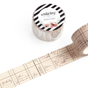 May include: Two rolls of washi tape. One roll is unrolled, displaying a vintage ledger design with handwritten script and grid lines. The other roll is upright, with a black and white striped top and the words "wintertime" and "Washi Tape".