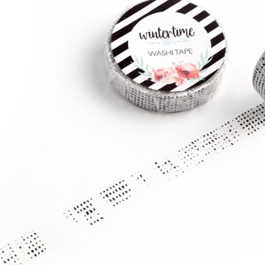 May include: A roll of black and white patterned washi tape with a label that reads "wintertime" and "WASHI TAPE". The tape has a subtle dotted pattern.
