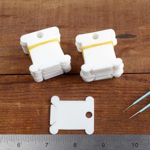 May include: A set of three ceramic mugs with a speckled, matte finish. The mugs are in shades of cream, light gray, and dark gray. Each mug has a simple, minimalist design and a rounded handle.