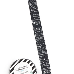 Washi tape with details from a vintage music dictionary. Black background.