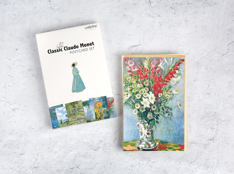 May include: A postcard set featuring the art of Claude Monet. The set includes a box with an illustration of a woman in a blue dress and a postcard with a floral still life. The box reads "The Classic Claude Monet POSTCARD SET."
