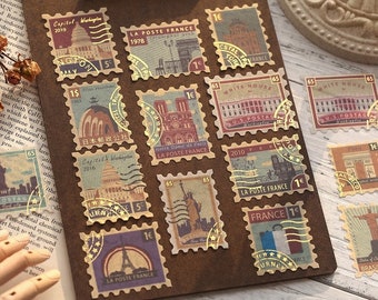 Könnte beinhalten: Eine Sammlung von Briefmarken im Vintage-Stil mit verschiedenen Sehenswürdigkeiten und Orten aus aller Welt. Die Briefmarken sind auf Papier mit einer strukturierten Oberfläche gedruckt und haben einen goldenen Folienschimmer. Die Briefmarken zeigen Bilder des Kapitols in Washington, D.C., der Kathedrale Notre-Dame in Paris, des Weißen Hauses und des Eiffelturms.