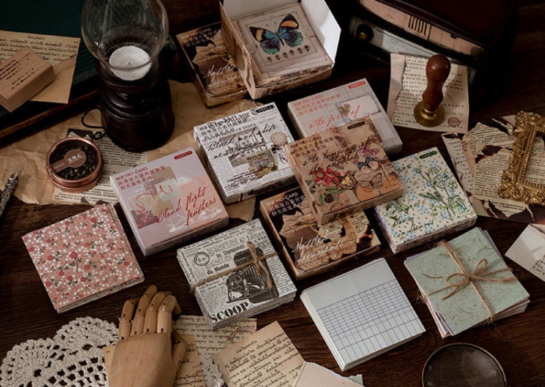 May include: Assortment of decorative paper ephemera with various designs and patterns. Includes floral, geometric, and text-based designs. Some papers have a vintage aesthetic.